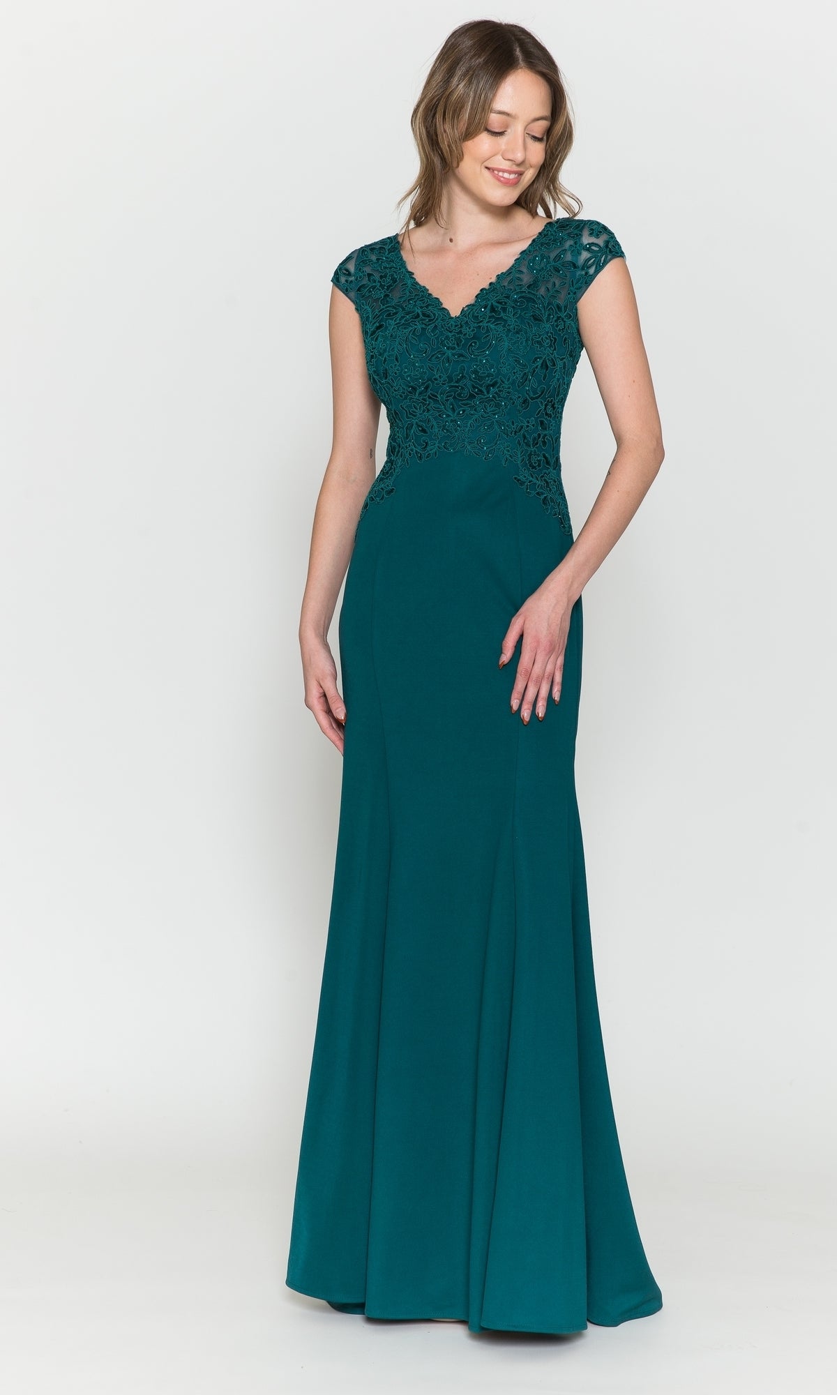 A woman in the Cap-Sleeve Embroidered Jersey Long Prom Dress 8558, emerald color, featuring a floor-length design and lace-detailed bodice, stands against a plain white background.